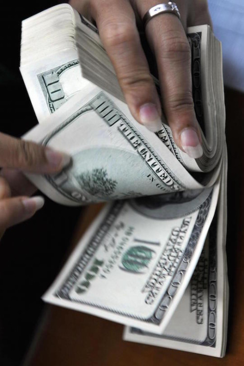 A money changer counts out US 100-dollar banknotes at a currency exchange shop in Jakarta on October 07, 2008. Indonesian President Susilo Bambang Yudhoyono said there was no danger of a repeat of the Asian financial crisis as the sharemarket took its biggest hit in a decade and the currency nosedived. AFP PHOTO / Bay ISMOYO (Photo credit should read BAY ISMOYO/AFP/Getty Images)