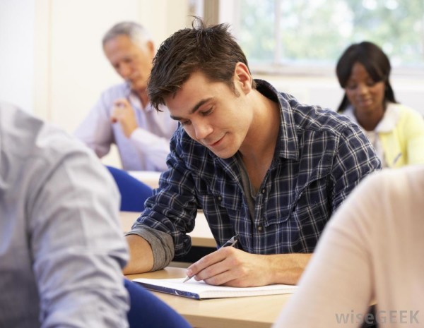 man-in-checkered-shirt-taking-test-at-desk