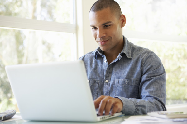 Young Man Using Laptop At Home