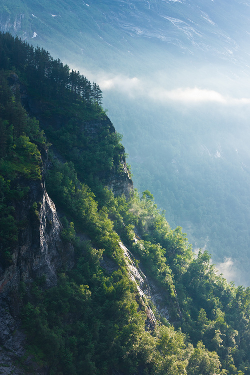 Cliff next to the Geiranger Fjord at sunset. The light and shadows created a really moody scenery.