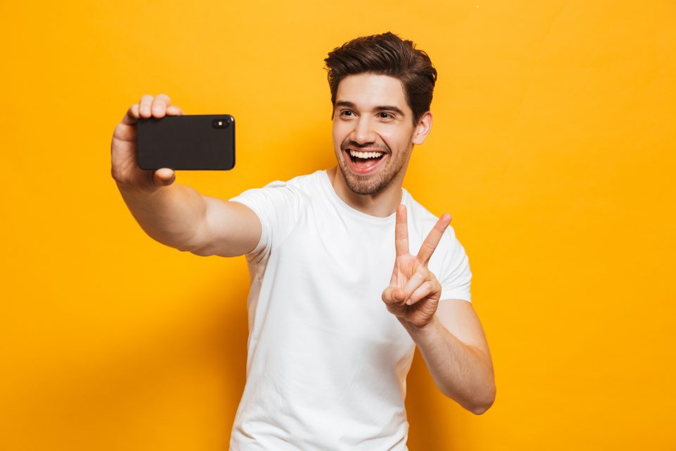 Portrait of a cheerful young man taking a selfie